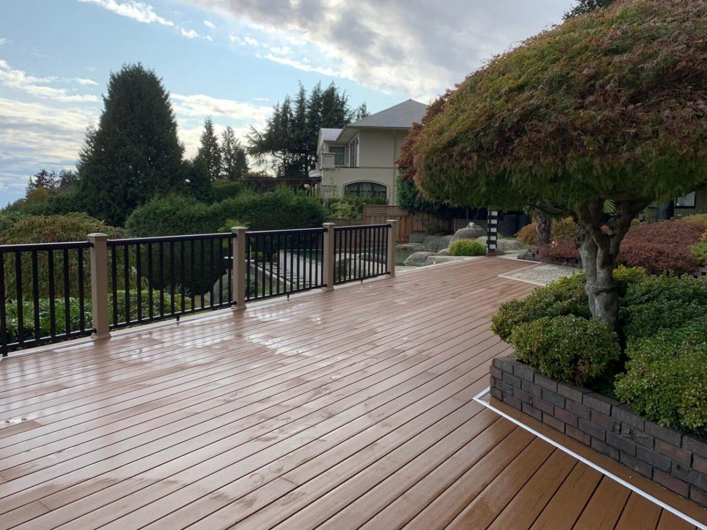 Wet wooden deck with landscaped garden view